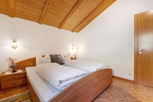 a bedroom with a large bed with white sheets at Malsethhof in Villandro