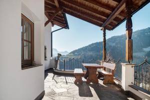 a patio with a table and benches on a balcony at Malsethhof in Villandro