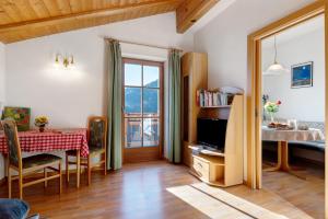 a living room with a dining room table and a window at Malsethhof in Villandro