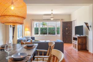 a living room with a couch and a table with chairs at Villa Jardin Tropical in Manilva