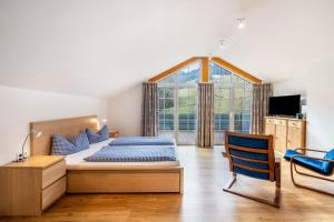a bedroom with a bed and a chair and a window at Josenhof in Wolfach