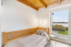 a bedroom with a bed and a large window at Brombeeruferhaus in Kosel
