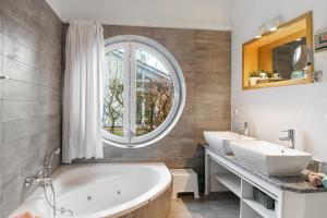 a bathroom with two sinks and a tub and a window at Brombeeruferhaus in Kosel +16 photos
