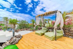 a patio with chairs and an umbrella on a wooden deck at Oceania Villa A in Chayofa
