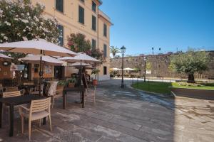 an outdoor patio with tables and chairs with umbrellas at Piazza 100 Croci in Bonassola