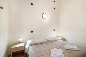 a white bedroom with a bed and two night stands at Monolocale La Pineta 46 in Albenga +22 photos