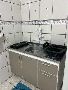 a small kitchen with a sink and a stove at Vila do Chaves Prof Girafales 15 in Itajaí