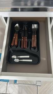 a tray with utensils in a drawer in an oven at Vila do Chaves Prof Girafales 15 in Itajaí