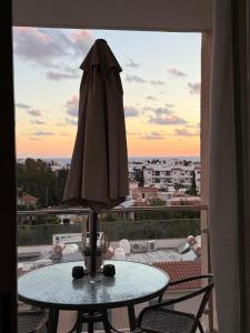an umbrella sitting on a table in front of a window at Stunning Sea View Resort Pools Spa Gym Balcony in Paphos +16 photos
