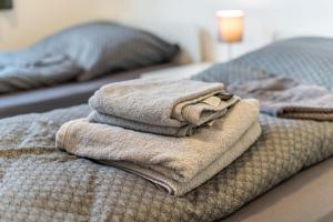 a pile of towels sitting on top of a bed at Speicherapartment in Warendorf