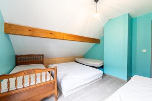 two beds in a room with blue walls at Le Revers in Aillon-le-Jeune