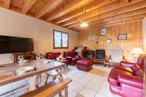 a living room with red furniture and a flat screen tv at Le Revers in Aillon-le-Jeune