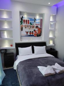 a bedroom with a bed and a painting on the wall at Anemi Leros Apartments 3 in Panteli