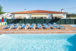 a group of lounge chairs and a swimming pool at Bungalow D in Pontevedra