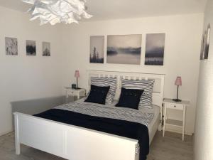 a bedroom with a white bed with black and white pillows at Ferienwohnung Bäumchenblick in Müllheim
