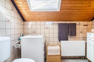 a bathroom with a white refrigerator and a wooden ceiling at Fewo Georg in Pfullendorf +14 photos