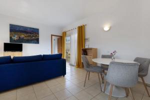 a living room with a blue couch and a table at La Finca Las Estrellas in Tarajalejo