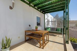 a patio with a wooden table and a bench at La Finca Las Estrellas in Tarajalejo +37 photos