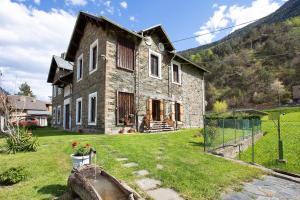 an old stone house with a fence in front of it at Casa Tua - Avise in Avise