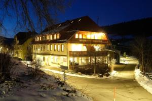 a large house in the snow at night at Gästehaus Krone in Sankt Georgen im Schwarzwald