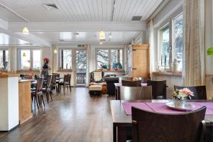 a dining room with tables and chairs and windows at Gästehaus Krone in Sankt Georgen im Schwarzwald
