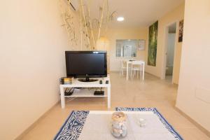 a living room with a television and a table at Barlovento in Algarrobo