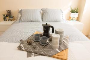 a tray with a tea kettle and cups on a bed at Barlovento in Algarrobo