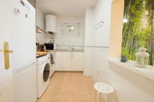a kitchen with a white refrigerator and a sink at Barlovento in Algarrobo +12 photos