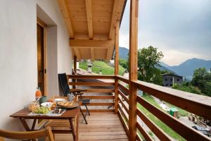 a balcony with a table and a view of mountains at Bio Maso Nido Verde in Frassilongo