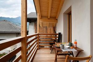 a wooden balcony with a table and chairs on it at Bio Maso Nido Verde in Frassilongo