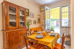 a dining room with a table and a china cabinet at Casina La Torretta - By The Walls in Lucca