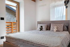 two teddy bears sitting on a bed in a bedroom at Bio Maso Nido Verde in Frassilongo