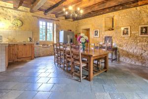 a large kitchen with a wooden table and chairs at La Bourgeoisie in Domme