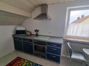 a kitchen with a stove top oven next to a window at Ferienwohnung Familie Kleinbauer in Wirsberg