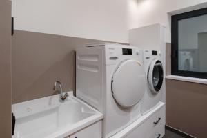 a white washing machine in a bathroom with a window at Chalet Ski in Selva di Val Gardena