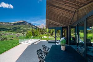 a house with a table and chairs on a patio at Chalet Ski in Selva di Val Gardena