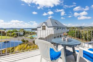 eine Terrasse mit einem blauen Tisch und Stühlen auf dem Balkon in der Unterkunft Aloha Seaview Resort Motel in Paihia