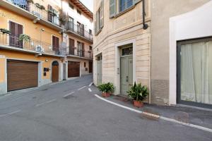 an empty street with two plants in front of buildings at Viasambuco in Iseo
