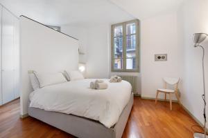 a white bedroom with a white bed and a window at Viasambuco in Iseo