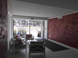 a living room with two chairs and a red wall at Gardensuite Binz in Binz