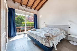 a bedroom with a bed and a large window at Al Segnavento Fasanella in Toscolano Maderno