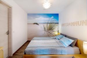 a bedroom with a bed and a painting of the beach at Ferienwohnung mit eigenem Eingang in Deggenhausertal