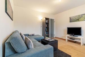 a living room with a blue couch and a tv at Ferienwohnung Smithson in Biberach