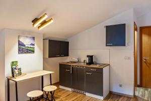 a small kitchen with a counter and two stools at Appartement by Blahut Vacation - dg in Ehrwald