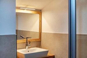 a bathroom with a sink and a mirror at Appartement by Blahut Vacation - dg in Ehrwald +8 photos