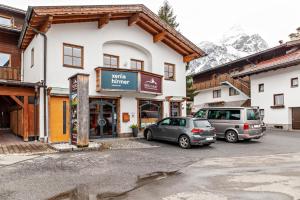 two cars parked in a parking lot in front of a building at Appartement by Blahut Vacation - dg in Ehrwald