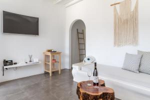 a white living room with a bottle of wine on a table at Ow Andros Suite 2,Private Whirlpool in Andros