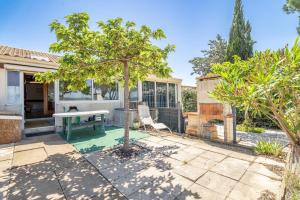 a patio with a table and a tree at Les Eaux Vives 1 in Fleury