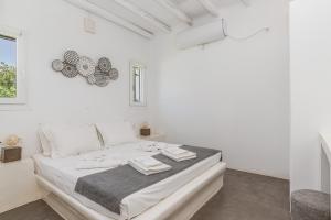 a white bedroom with a large bed in a room at Ow Andros Suite 2,Private Whirlpool in Andros +20 photos