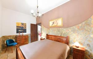 a bedroom with a bed and a blue chair at Villa Parisi con piscina in Syracuse +33 photos